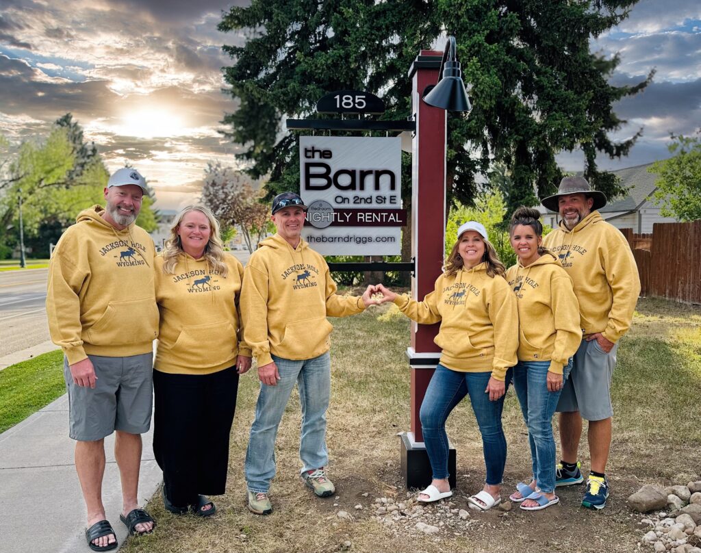Family standing in front of The Barn sign