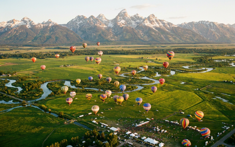 Hot air balloons over Teton Valley at golden hour with Grand Teton mountains in background, Driggs Idaho 4th of July